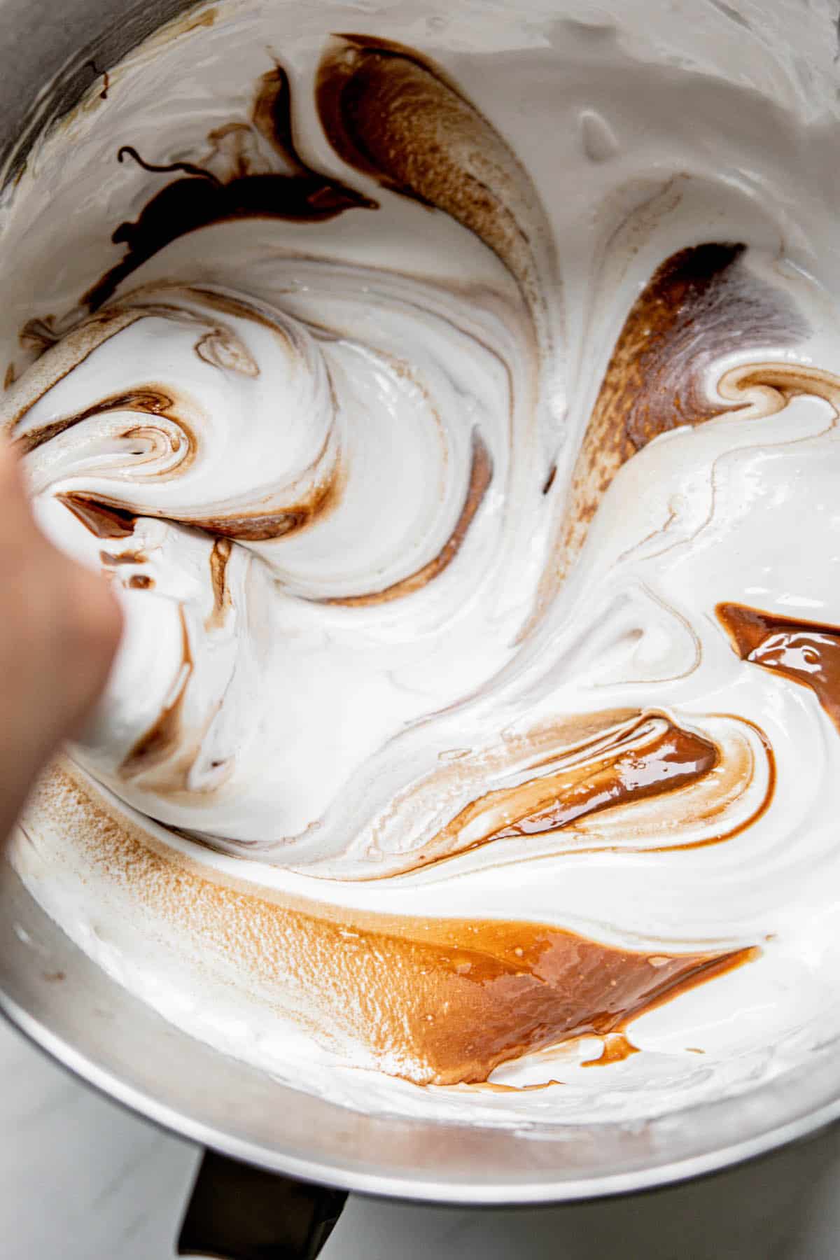 knife swirling chocolate into marshmallow.
