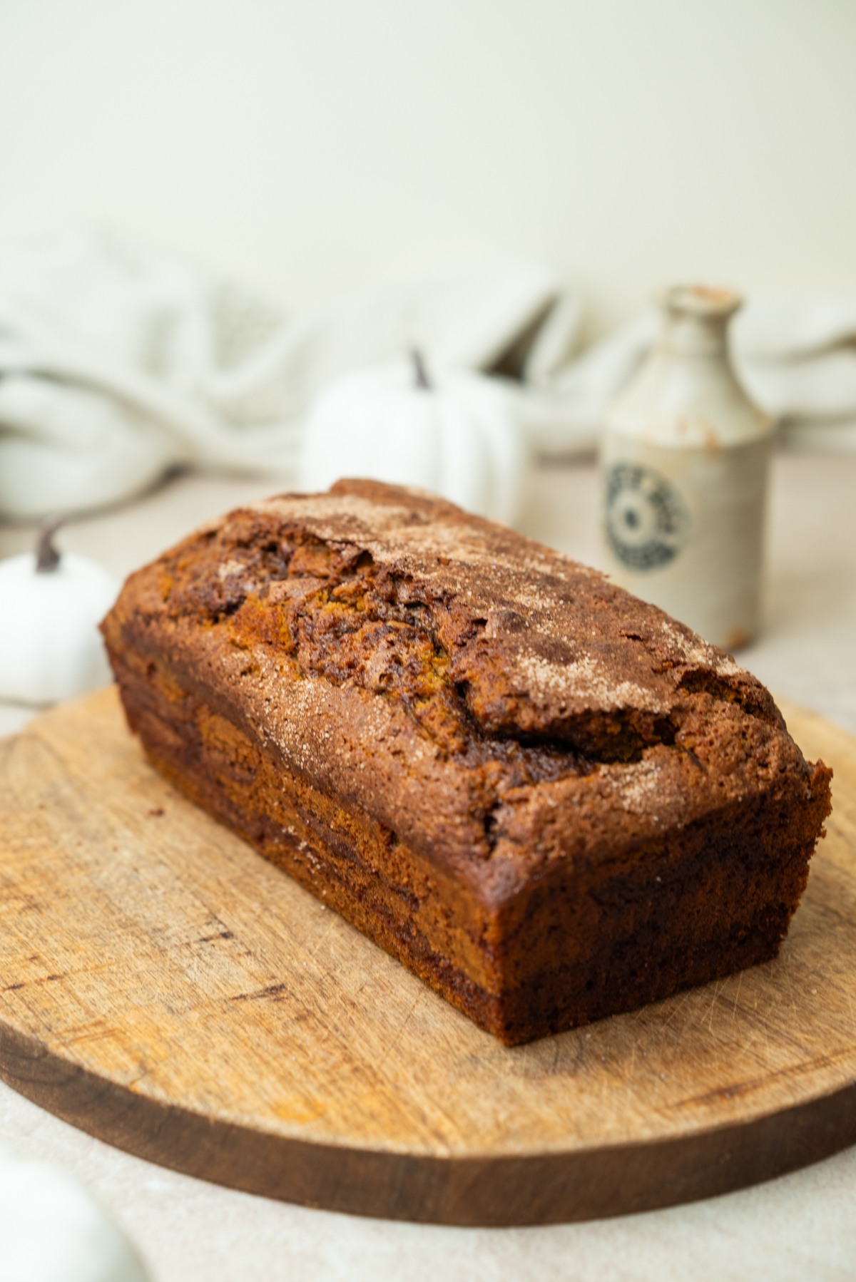 A loaf of baked pumpkin bread on a wooden cutting board.